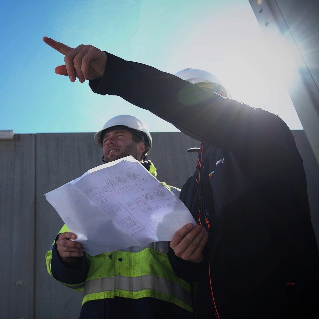 Technicien Atawey et un client effectuant une visite de chantier d'une station hydrogène.